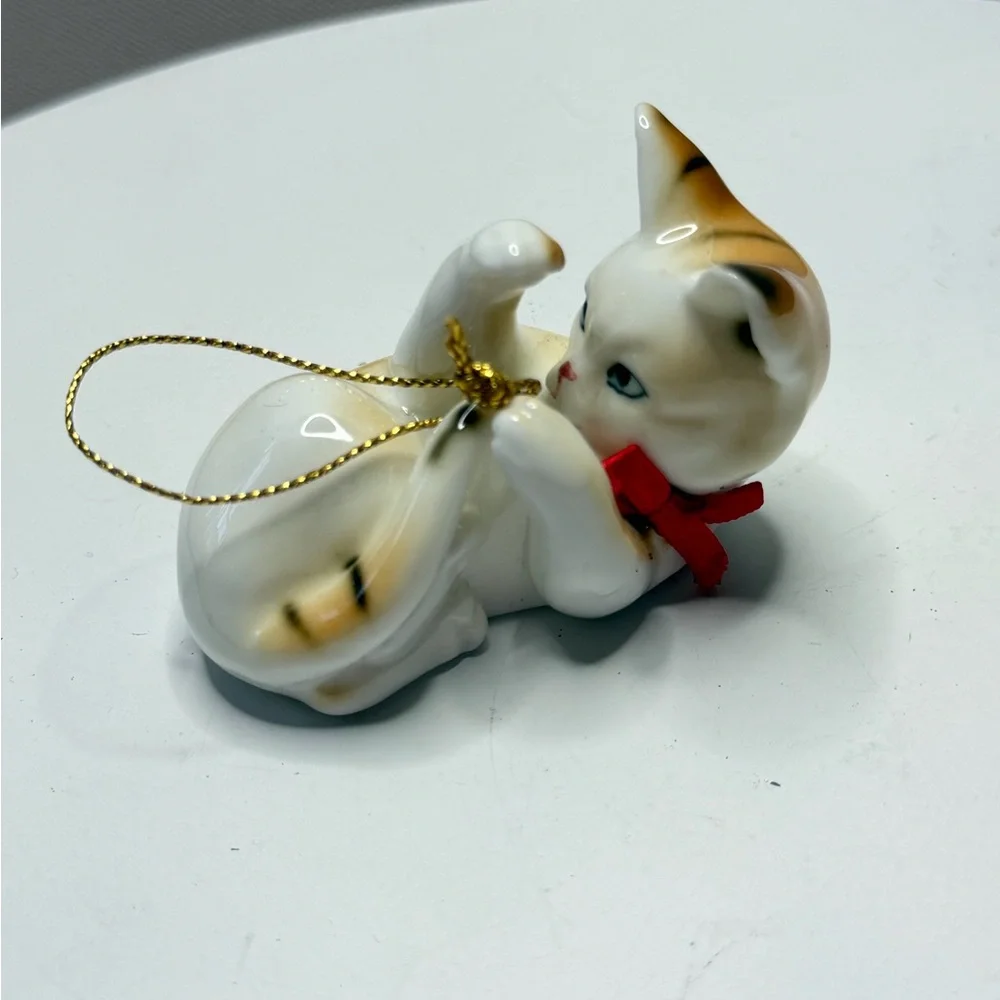 Decorative White and Tan Ceramic Cat Ornament with Red Bow